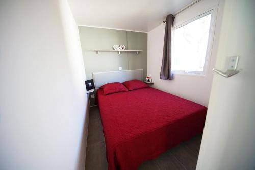 アルジェレス・シュル・メールにあるCamping Sol y Marの小さなベッドルーム(赤いベッド1台、窓付)