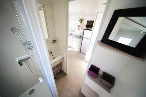 a bathroom with a tub and a sink and a mirror at Camping Sol y Mar in Argelès-sur-Mer