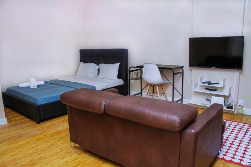 uma sala de estar com um sofá e uma cama em Studio 110 em Luanda