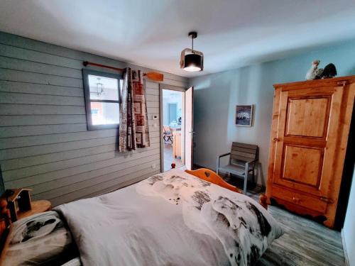 a bedroom with a bed and a window at Appartement cosy, esprit montagne, au cœur du village in Chapelle-des-Bois