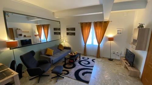 a living room with a blue couch and a television at Patras Golden Suite in Patra