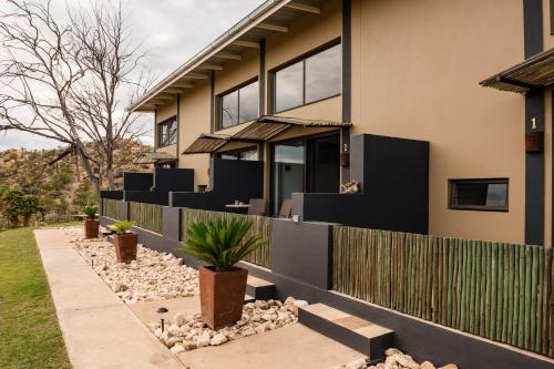 una casa con una valla y plantas delante de ella en Kapps Mountain Self Catering Accommodation, en Voigtland
