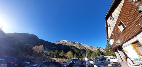 a parking lot with cars parked in front of a mountain at Сладко студио в Пирин с голф и СПА комплекс in Razlog