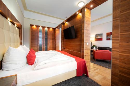 1 dormitorio con 1 cama y 1 sofá rojo en ACHAT Sternhotel Bonn en Bonn