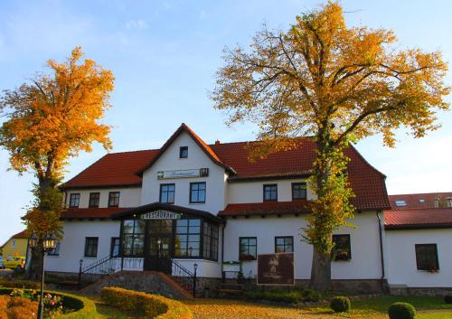 un grand bâtiment blanc avec un toit rouge dans l'établissement Land gut Hotel Hermann, à Bentwisch