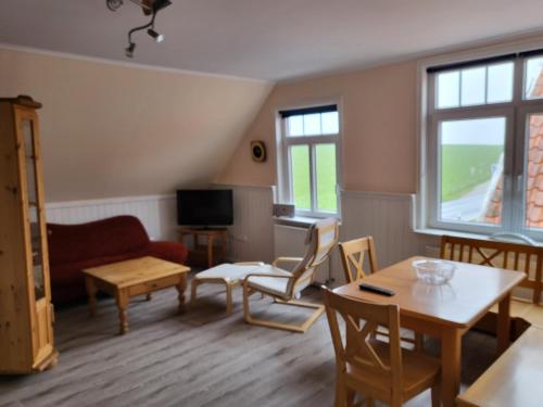 a living room with a couch and a table and chairs at Urlaub im blauen Haus in Sehestedt