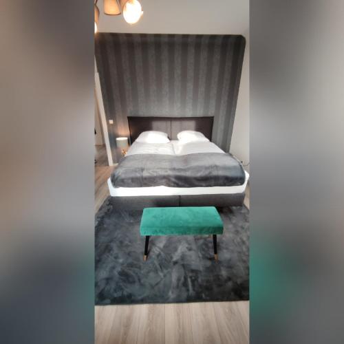 a bedroom with a bed and a green stool at Ferienvilla in Eppelborn