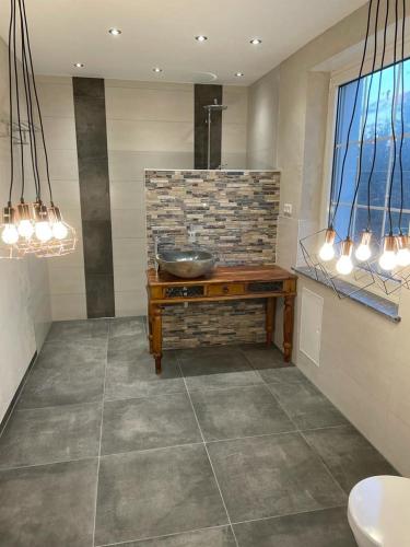 a bathroom with a sink and a stone wall at Ferienvilla in Eppelborn
