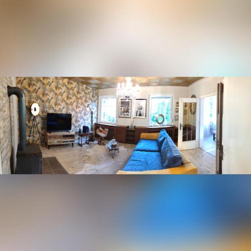 a living room with a blue couch and a tv at Ferienvilla in Eppelborn