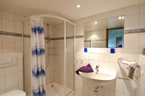 a bathroom with a sink and a shower and a toilet at Oome Tilles Hüs in Norddorf
