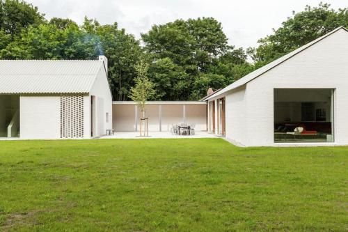 a white house with a lawn in front of it at Coccinelle in Biggekerke