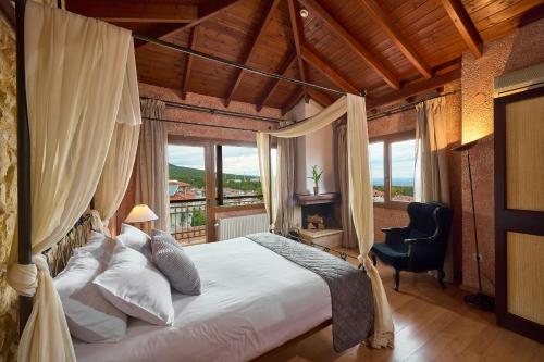 a bedroom with a large bed and a large window at Olympus Mediterranean Boutique Hotel in Litochoro