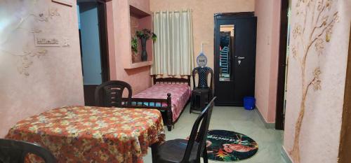 a room with two beds and a table and chairs at JJ's Holiday Home in Thanniyam
