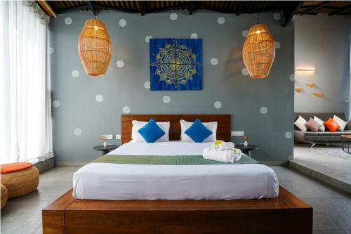a bedroom with a large bed with blue walls and lights at Sixth Element in Kushālnagar