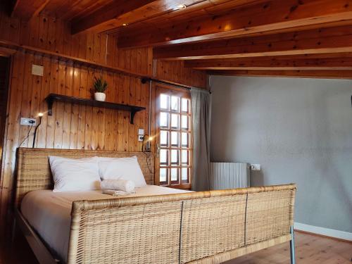 a bedroom with a rattan bed with a window at Duplex en Pas de la casa in Pas de la Casa