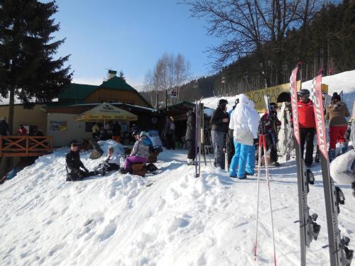 a group of people sitting in the snow at Penzion Alenka in Špindlerův Mlýn
