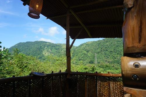 a view from the porch of a house with mountains in the background at The Valley Tayrona hostel- A social jungle hostel in El Zaino