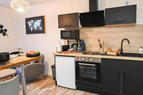 - une cuisine avec un comptoir, un évier et une table dans l'établissement L'Albizia #Hyper-centre #Marché couvert, à Cognac