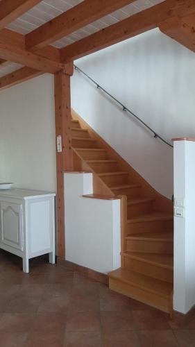 a wooden staircase in a room with a table at Charmant Logement T2 campagne 