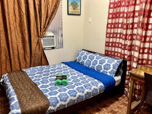 a bedroom with a bed with two green cups on it at May’s Home Away from Home in Cebu City