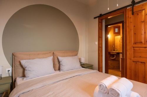 - une chambre avec un grand lit et des oreillers blancs dans l'établissement The Fern House, à Makrinitsa