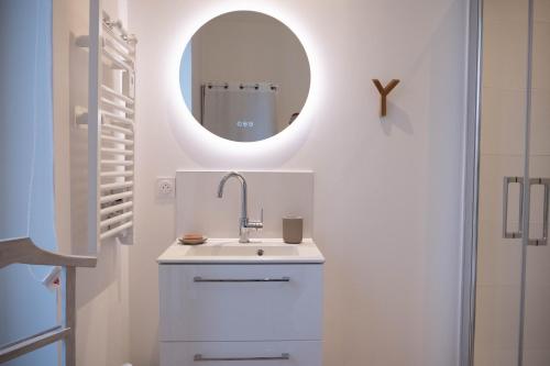 La salle de bains blanche est pourvue d'un lavabo et d'un miroir. dans l'établissement au42dotBzh, à Saint-Brieuc