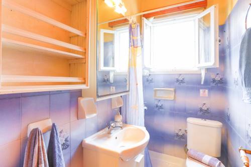 ein Bad mit einem Waschbecken, einem WC und einem Fenster in der Unterkunft Agathi House in Gaios