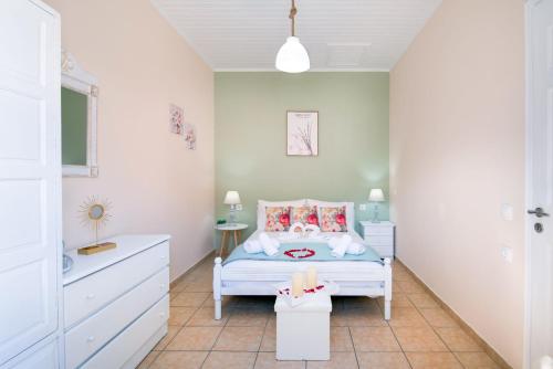 Dormitorio pequeño con cama y lavamanos en Xenia House, en Gáios