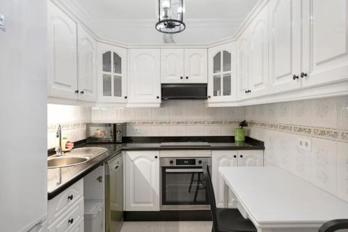 a white kitchen with white cabinets and a sink at Alpispa in Arrecife