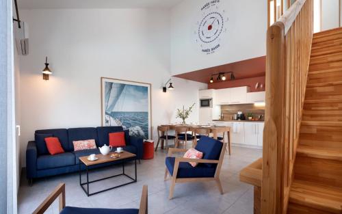 a living room with a blue couch and a table at Pierre & Vacances Premium Les Villas d'Olonne in Les Sables-dʼOlonne