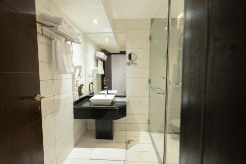 a bathroom with a sink and a shower at Mira Business Hotel in Riyadh