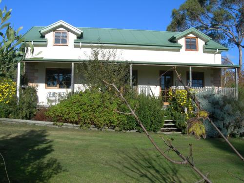 a white house with a green roof at Platypus Park Country Retreat in Bridport
