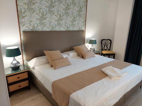 a bedroom with a large white bed with two lamps at Hostal GARDEN ROUS in Paiporta