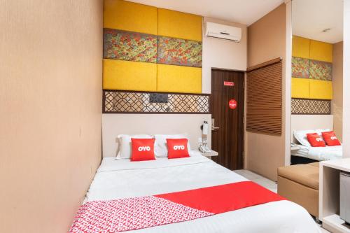 ein Schlafzimmer mit einem Bett mit roten Kissen darauf in der Unterkunft SUPER OYO Flagship 91963 Series Style Hotel in Putat-wetan
