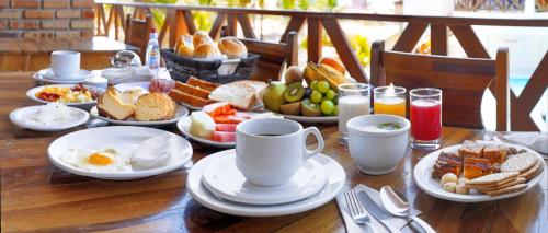 a wooden table with breakfast foods and drinks on it at Vila Jeri Hotel in Jericoacoara