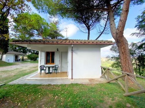 a small white house with a table and chairs at Camping Village Mar y Sierra in San Costanzo
