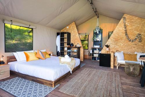 ein Schlafzimmer mit einem großen Bett in einem Zimmer in der Unterkunft Cicada Luxury Camping in Kiama