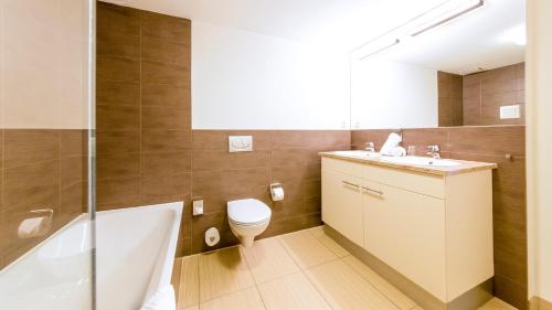 een badkamer met een toilet, een wastafel en een bad bij Michels Villa Nordsee in Norderney