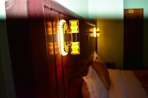 a headboard of a bed with a light on it at Monrovia Guest House in Nakuru