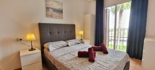 Un dormitorio con una cama con zapatos rojos. en Homes of Spain, Al Andalus Residencial apartamento IN, primera planta, WIFI, en Playas de Vera