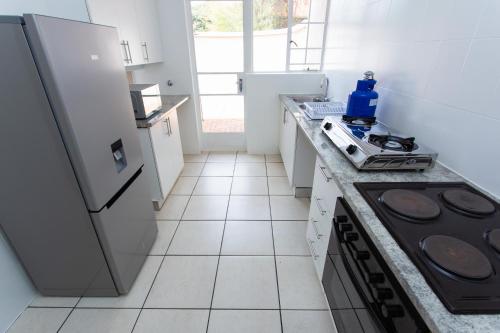a white kitchen with a stove and a refrigerator at Country Life Park in Johannesburg