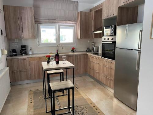 una cocina con armarios de madera y electrodomésticos de acero inoxidable en Olive Inn City, en Drama