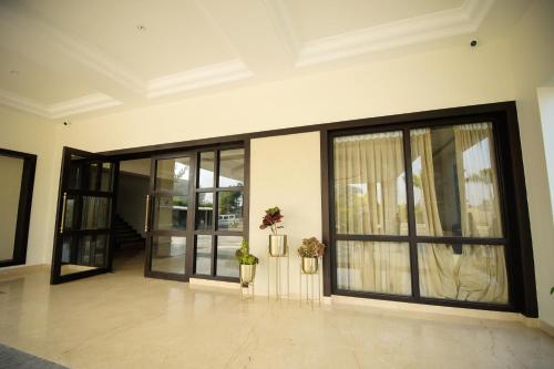 an empty lobby with glass doors and flowers on the floor at Enrise by Sayaji Rewa in Rewa