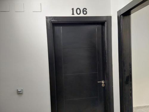 a black door with the number on the wall at Hostal GARDEN ROUS in Paiporta