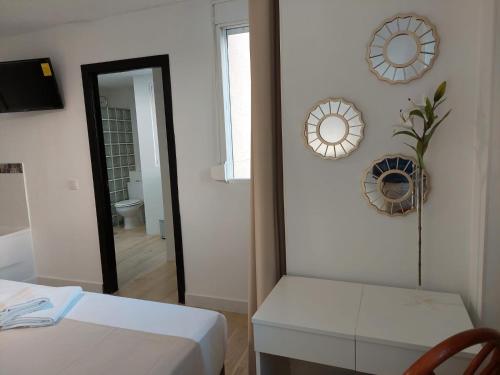 a room with a bed and a mirror and a table at Hostal GARDEN ROUS in Paiporta