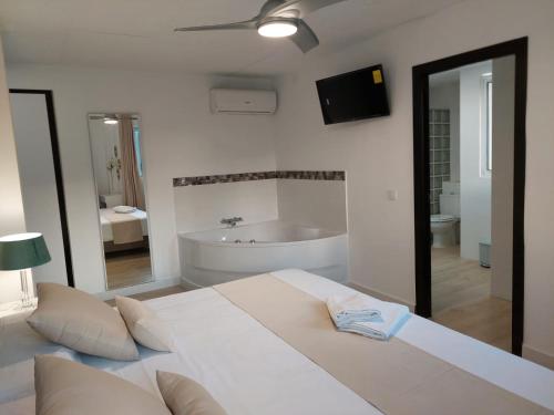 a bedroom with a large bed and a bath tub at Hostal GARDEN ROUS in Paiporta