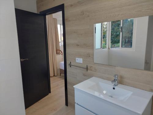 a bathroom with a sink and a mirror at Hostal GARDEN ROUS in Paiporta
