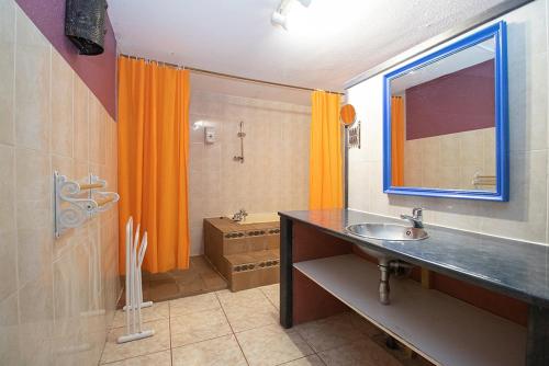 a bathroom with an orange shower curtain and a sink at Apartaments Turistics Natural Suites Manzano 3000 in Pas de la Casa