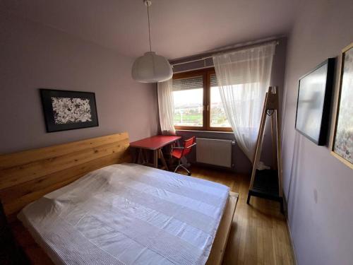 sypialnia z łóżkiem, biurkiem i oknem w obiekcie Artist's Apartment in Prishtina w Prisztinie