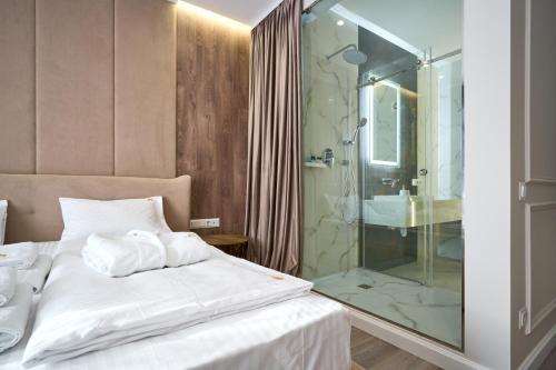 a bedroom with a bed and a glass shower at Olimp Hotel in Bukovel
